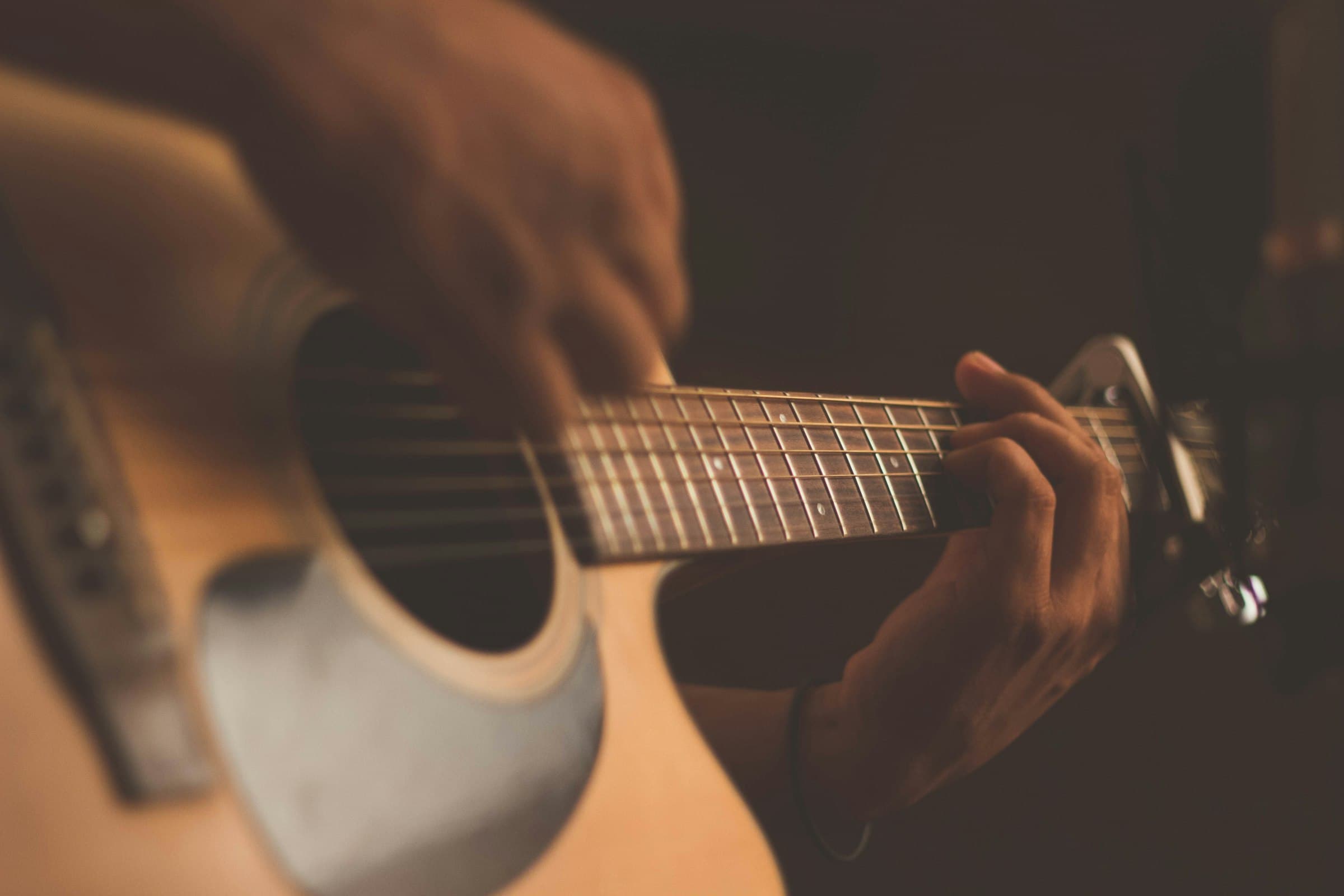 Close-up of hands playing an acoustic guitar