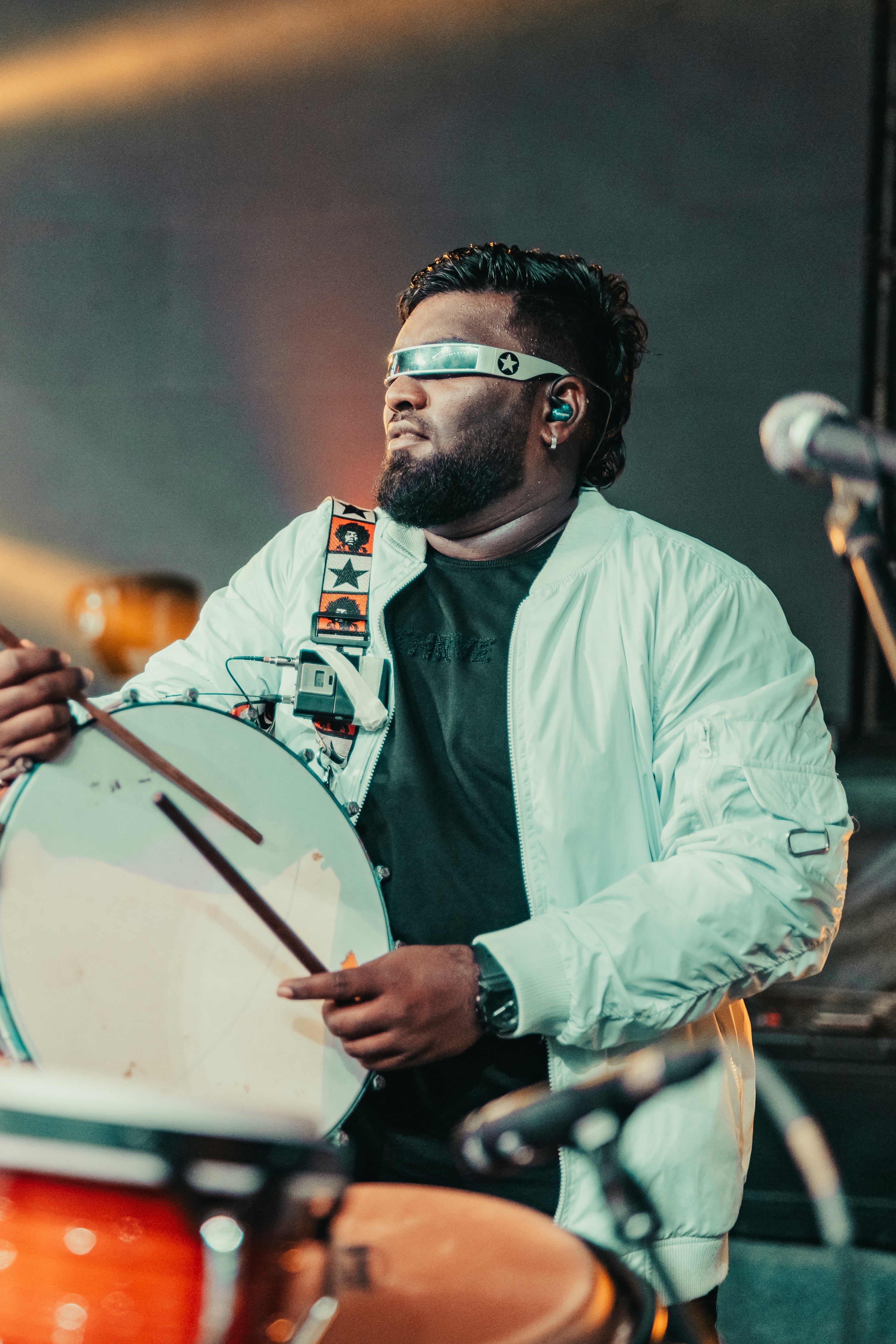Richard playing a frame drum behind congas